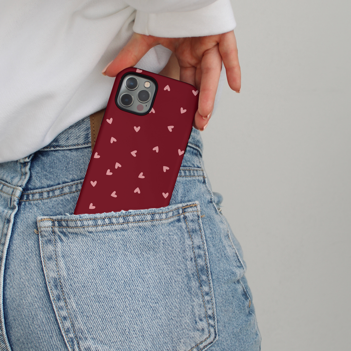 Mulberry Hearts patterned Coconut Lane Tough MagSafe phone case being slipped into blue jeans back pocket.