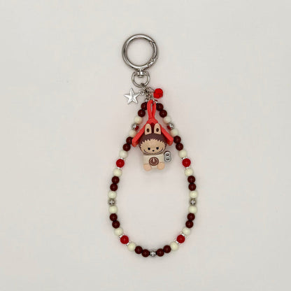 Keychain with beads and small character charm on a light gray background