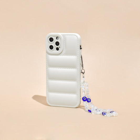 White quilted phone case with a beaded Crystal Evil Eye strap, shown on a beige background.