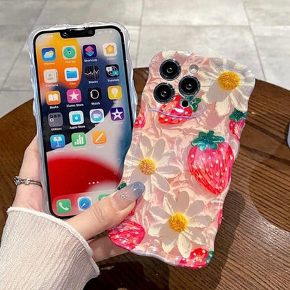 Pink wavy iPhone case featuring painted style red strawberries and white daisies with yellow centers.