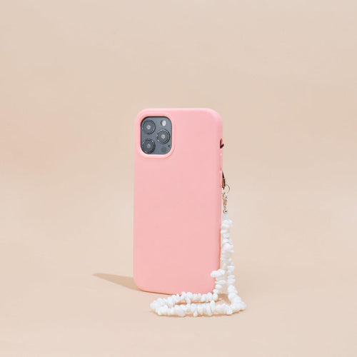 Pink smartphone case with clear Crystal Phone Strap stands upright against a beige background.