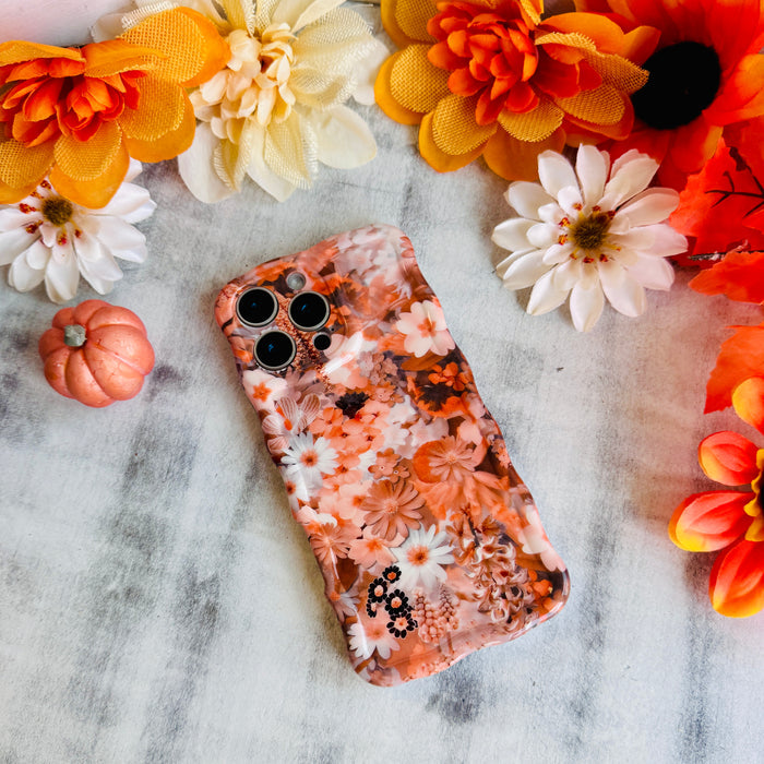 Fall Blooms Wavy Luxe MagSafe iPhone case with a warm autumn floral print in orange and cream from Fancy Bands
