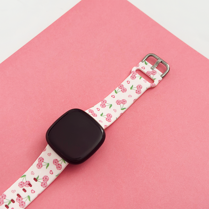 Coconut Lane Fitbit strap with disco cherries pattern on a pink background.