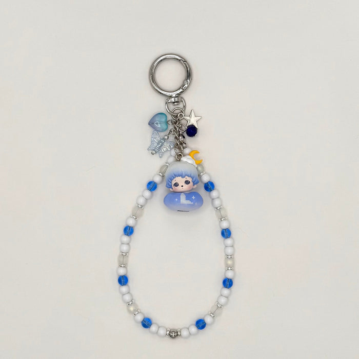 Keychain with beads and a small figure toy on a light gray background