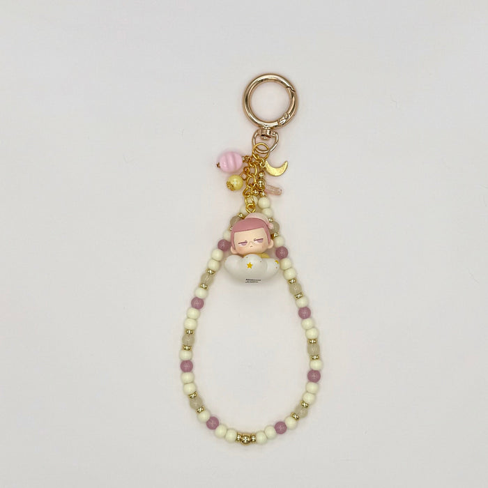 Keychain with beads and small figurine on a light gray background