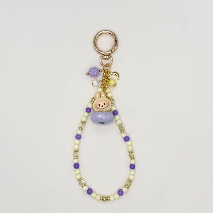 Beaded keychain with charms on a light gray background