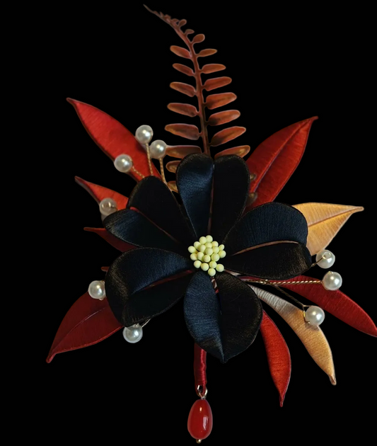 Handcrafted Chanhua brooch featuring thread-wrapped pink flowers, green leaves, and a red Double Happiness symbol.