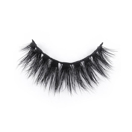 A single strip of dramatic, black, wispy false eyelashes curves in a semi-circle against a white background.
