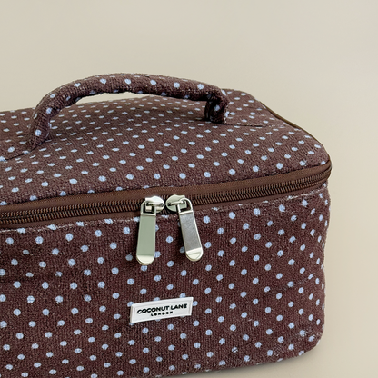 Brown and blue polka dot travel towel vanity case by Coconut Lane on a beige background.